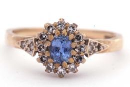 9ct gold sapphire and diamond cluster ring, the pale oval shaped sapphire multi-claw set and