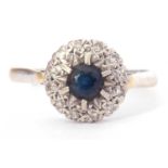 18ct white gold, sapphire and diamond cluster ring, the round central sapphire raised above a