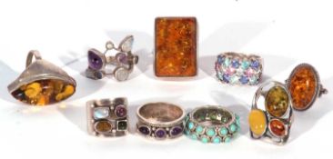 Nine modern white metal rings to include four amber examples