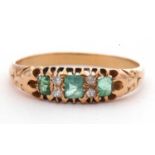 Green stone and small diamond ring featuring three pale green stones highlighted between with