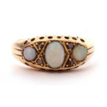 Antique opal and diamond ring centring an oval cabochon opal, flanked by two small round opal