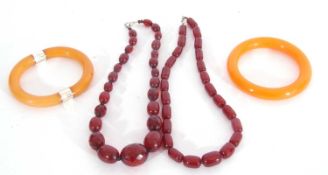 Mixed Lot: single row of cherry amber and faceted bead string necklace, two amber type bangles,