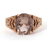 9ct gold and quartz set ring, the central oval faceted quartz raised between pierced textured