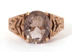 9ct gold and quartz set ring, the central oval faceted quartz raised between pierced textured