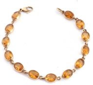 9ct gold and citrine bracelet featuring 13 gold framed oval faceted citrines, 18cm long