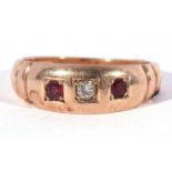 Diamond and ruby three stone ring centring an old cut diamond flanked by two round cut rubies,