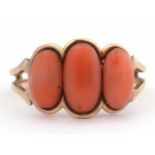 Vintage coral three stone ring featuring three graduated oval stones between pierced shoulders and