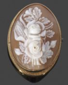 Carved cameo brooch of oval form depicting a floral spray, framed in a yellow metal mount (tested