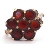 9ct gold and garnet cluster ring, a flowerhead design featuring seven small round faceted garnets,