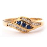 Sapphire and diamond cross-over style ring, centring three round faceted sapphires, channel set,