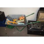 WHEELBARROW CONTAINING VARIOUS GARDEN TOOLS AND HOSE ATTACHMENTS