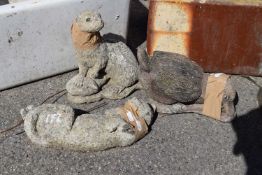 Three composite garden statues, one of an otter, one of a cat, one of a duck