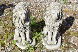 Pair of small composite seated lions, height approx 40cm