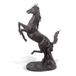 A contemporary bronzed metal model of a rearing horse set on a naturalistic base, 180cm high