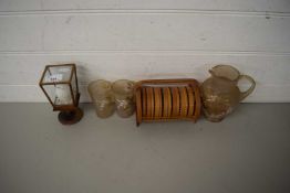 GILT DECORATED GLASS JUG AND BEAKERS, CASED PAINTED EGG AND A STAND OF COASTERS