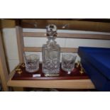 GLASS WHISKY DECANTER WITH MAHOGANY FINISH STAND AND TWO ACCOMPANYING TUMBLERS