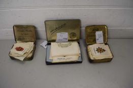 TWO VINTAGE BOOTS TINS CONTAINING MILITARY BADGES AND OTHER ITEMS, SOME MOUNTED ON SILK, TOGETHER