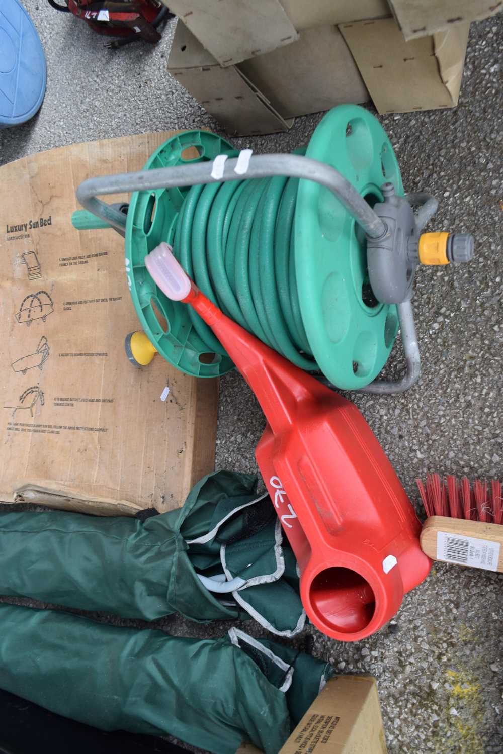 Hose reel with quantity of garden hose, together with a watering can