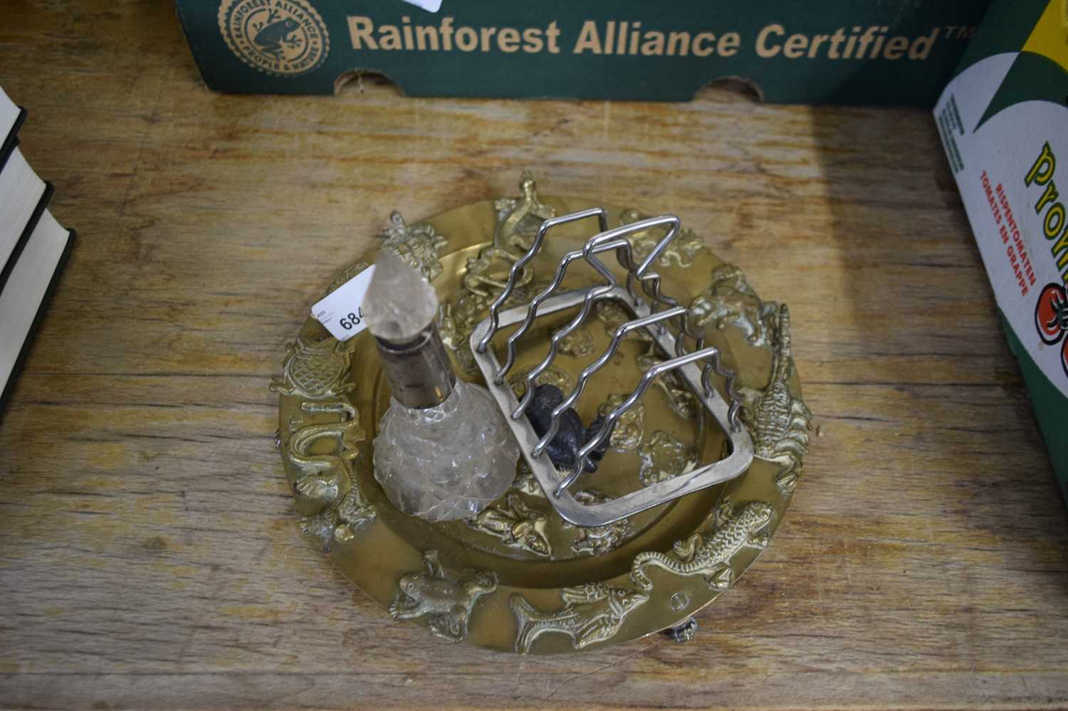 VARIOUS WARES TO INCLUDE AN EMBOSSED BRASS PLATE, A DRESSING TABLE BOTTLE AND A PLATED TOAST RACK