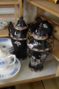 PAIR OF VINTAGE VASES AND COVERS, THE BLACK POTTERY GROUND DECORATED WITH FLOWERS