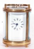Small carriage clock timepiece with white enamel dial and black Roman numeral hour markers, key