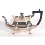 George V shaped oval tea pot with wavy apron, ebonised handle, raised on four trefoil and paw