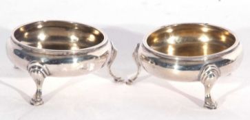 Pair of George III circular gilt lined salts with lightly gadrooned rims supported on three hoof