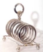 Victorian silver plated toast rack featuring seven circular divisions on a stretcher base, supported