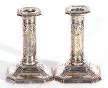 Pair of George V silver encased dressing table candlesticks of canted square form with sealed loaded