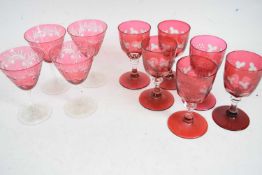 Group of cranberry wine glasses including a set of six of faceted form engraved with leaves and