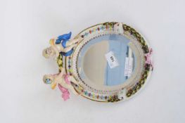 Continental porcelain oval mirror, the top with two cherubs, 23cm high