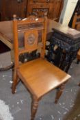 Pair of late Victorian oak hall chairs, the backs with spindle detail and central carved flower