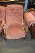 Victorian button back armchair with scrolled arms and short cabriole legs raised on casters,
