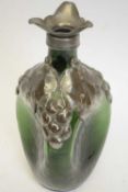 A 19th century green glass decanter of dimpled form with pewter top and applied pewter leaf and