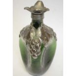 A 19th century green glass decanter of dimpled form with pewter top and applied pewter leaf and