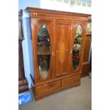 Edwardian mahogany wardrobe with moulded cornice over two mirrored doors and a panelled centre, with
