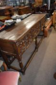 Oak Jacobean style three drawer sideboard with moulded detail raised on turned legs with a stretcher