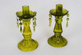Pair of green glass candlesticks with moulded decoration and droplets from the drip pan, 23cm high