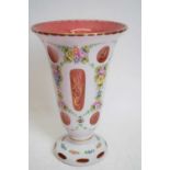 Bohemian type glass vase, cranberry coloured, with white overlay, painted with flowers, 23cm high