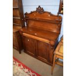 Victorian mahogany chiffonier of typical form with single shelf back, carved pediment and a base