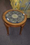 Early 20th century circular walnut veneered coffee table with inset needlework top under glass, 41cm