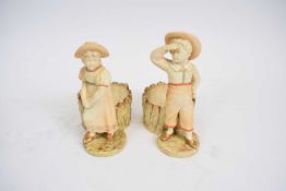 Pair of Royal Worcester figures of a boy and a girl with fern pots behind (2)