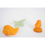 Small bag containing three carved animals including an amber coloured snail, and a jadeite fish (3)