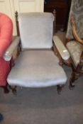 Victorian blue upholstered armchair raised on short tapering legs with casters