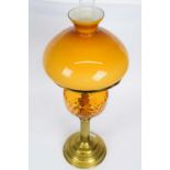 Victorian oil lamp with amber coloured reservoir and amber shade