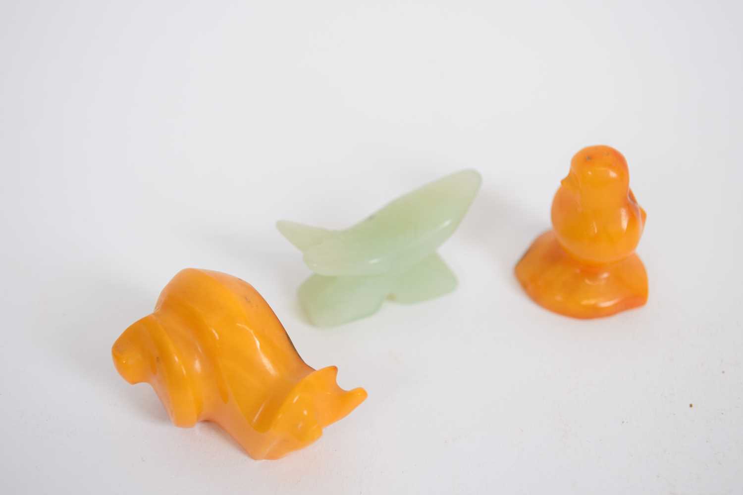 Small bag containing three carved animals including an amber coloured snail, and a jadeite fish (3) - Image 2 of 2