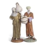 Two large 19th century Hadley Worcester figures of water carriers decorated in shot enamels the base