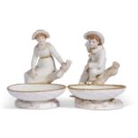 Pair of Royal Worcester figural comports decorated with a boy and a girl in Hadley style mounted