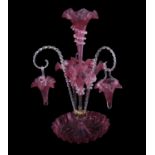 A large Victorian cranberry glass epergne with flower holders and two baskets supported by rope