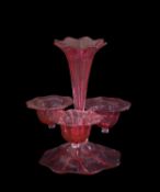 Cranberry glass epergne with petal shaped flower holders above a petal shaped base, 28cm high